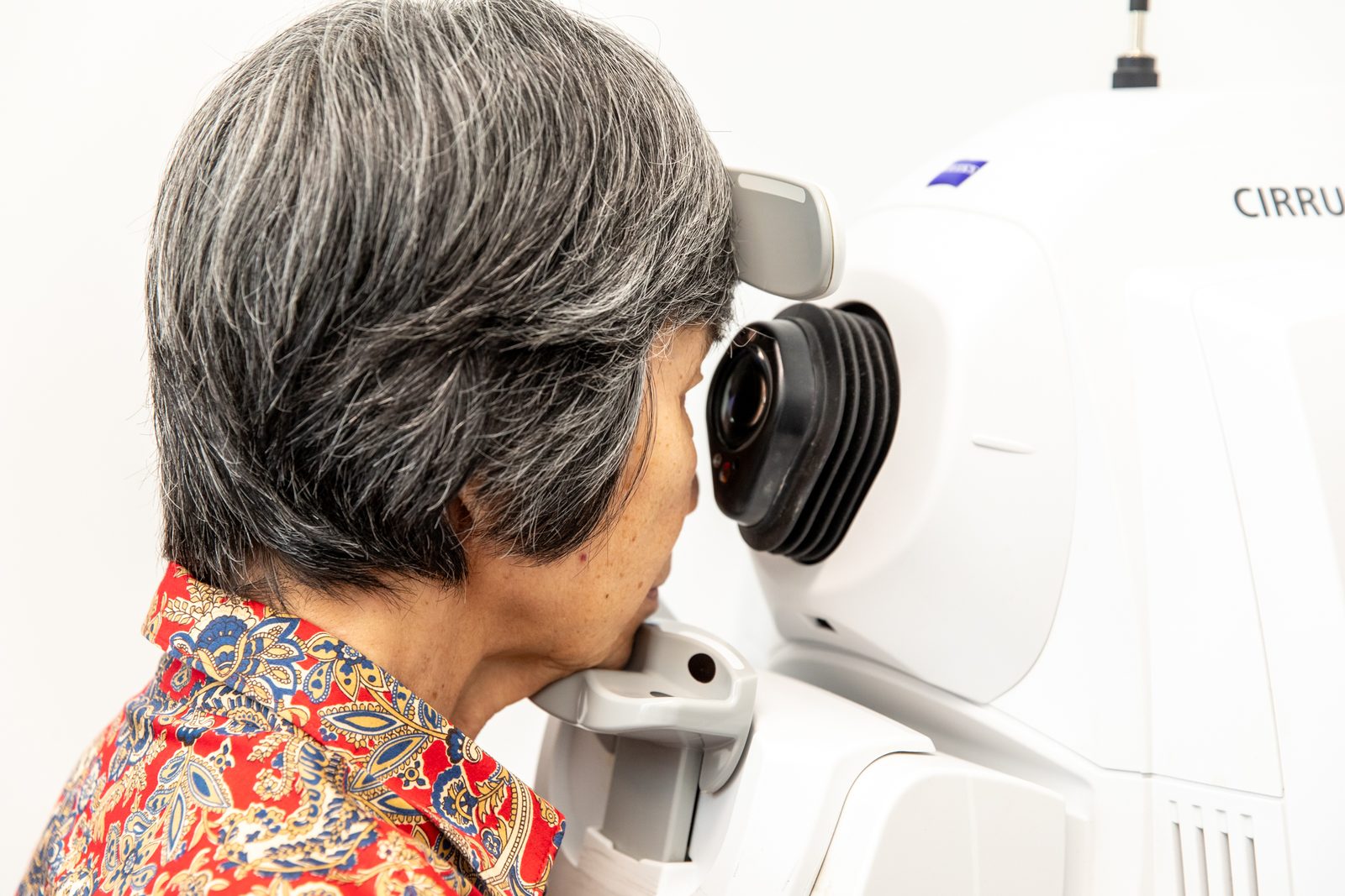 Patient seated at an optical coherence tomography scanner having the macula imaged at Eastwood Eye Surgery