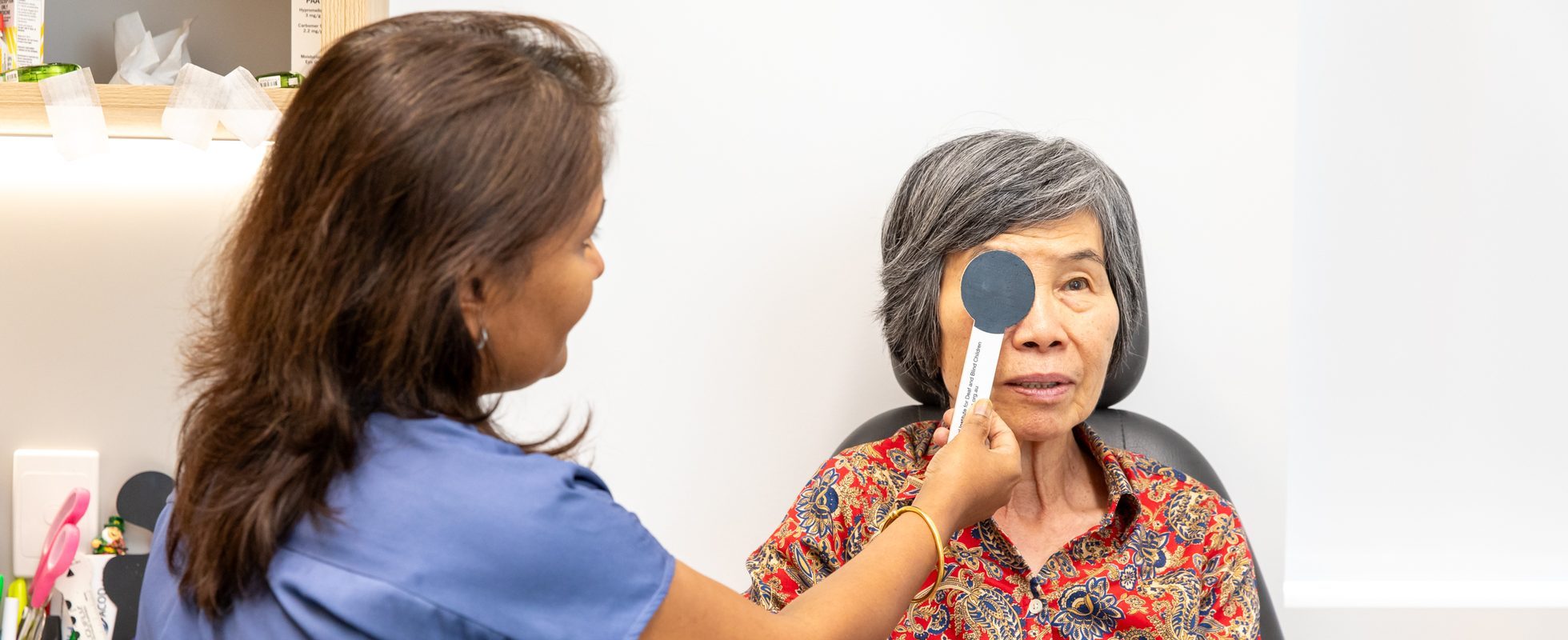 Eastwood Eye Surgery clinician checking a patient's vision with an occluder at a post-operative review