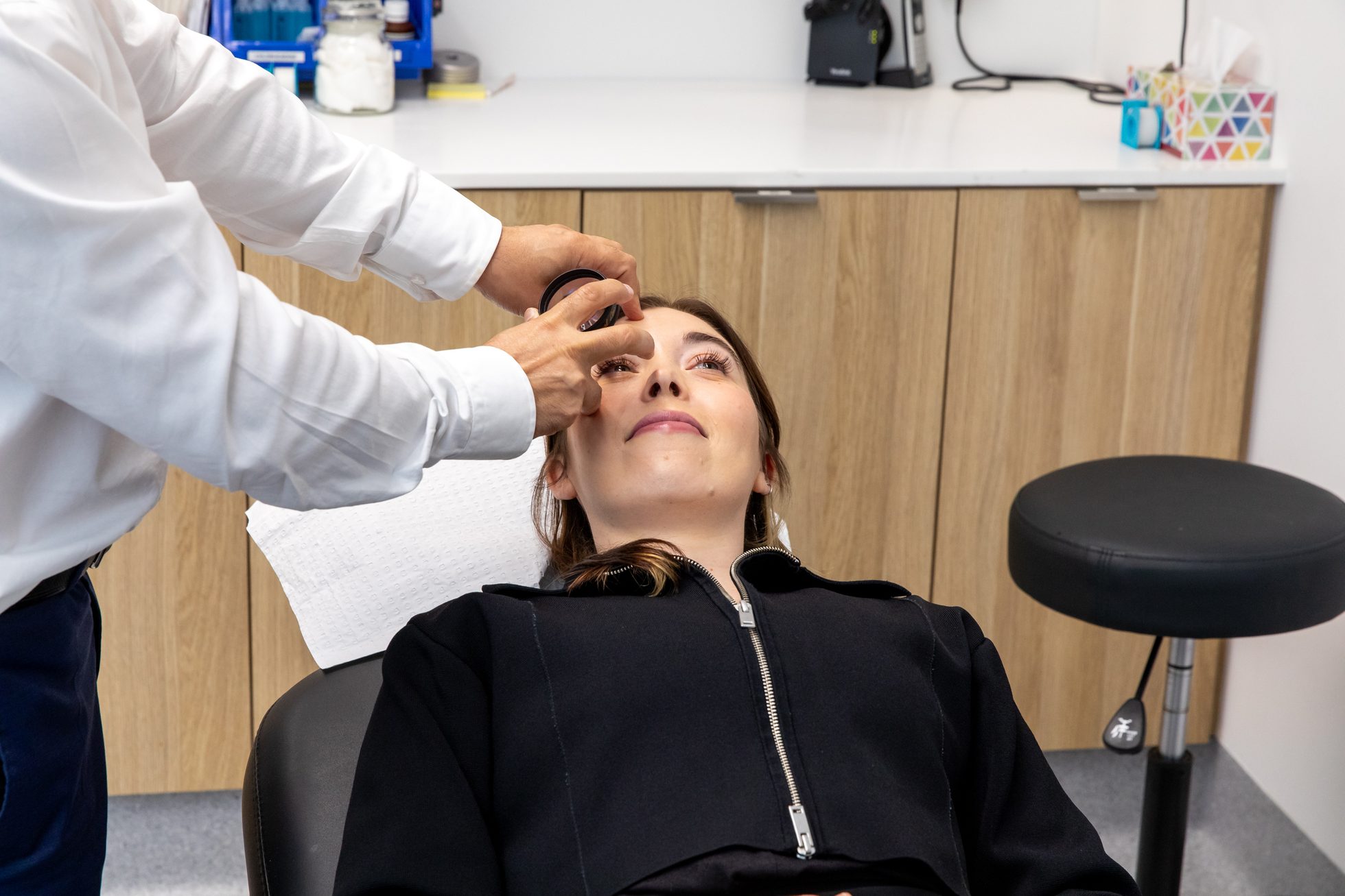 Eastwood Eye Surgery clinician instilling dilating drops into a reclined patient's eye before a diabetic retinal examination
