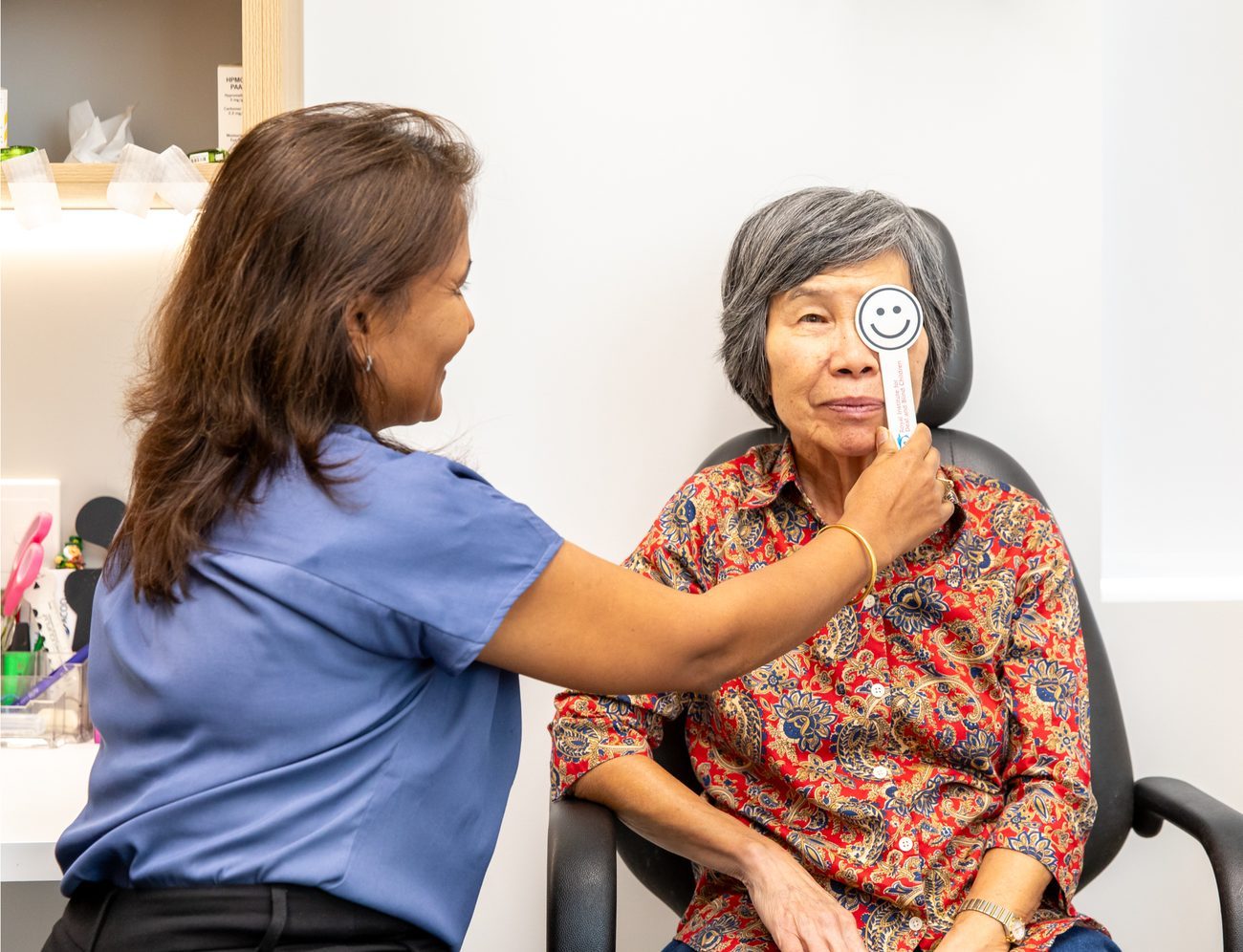 Eastwood Eye Surgery clinician holding an occluder over a patient's eye during a visual acuity test