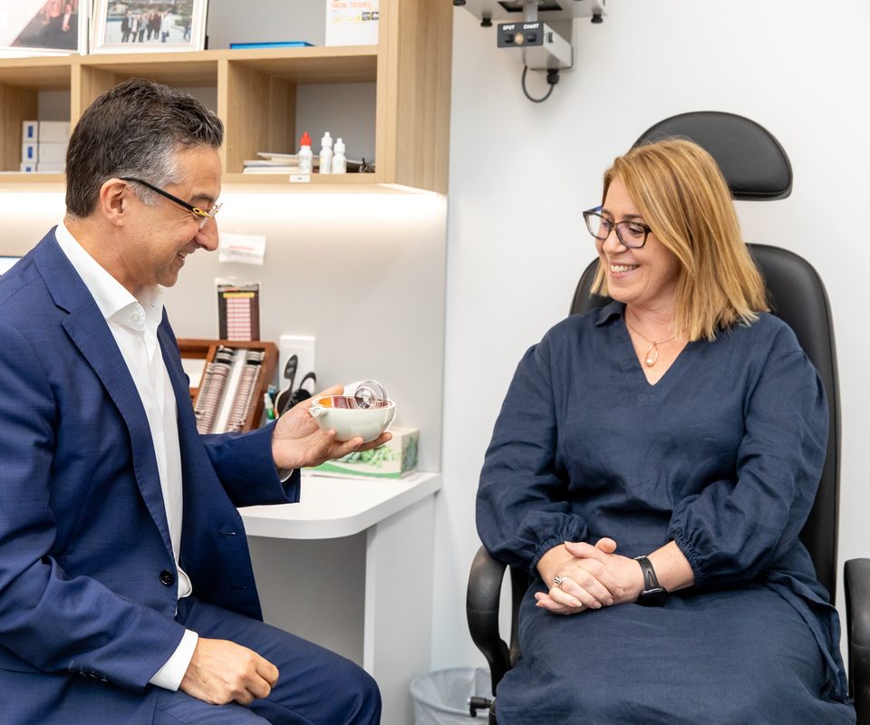 Eastwood Eye Surgery ophthalmologist holding a cross-section model of the eye to explain the retina and vitreous to a patient