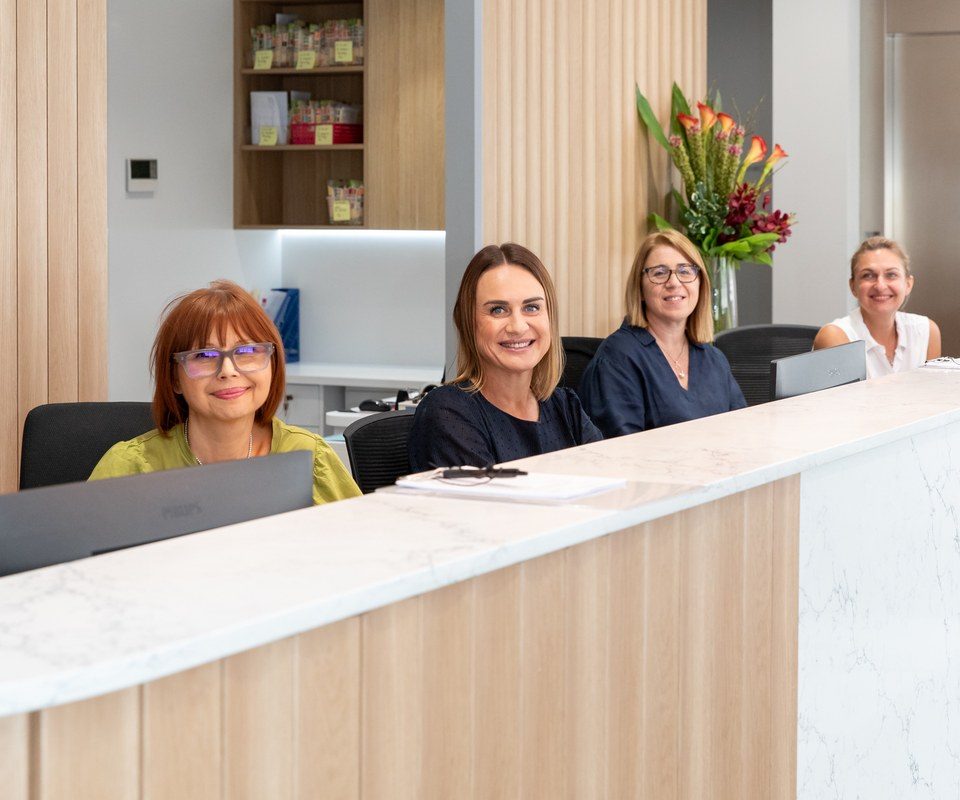 Four Eastwood Eye Surgery reception staff at the front desk, ready to welcome arriving patients