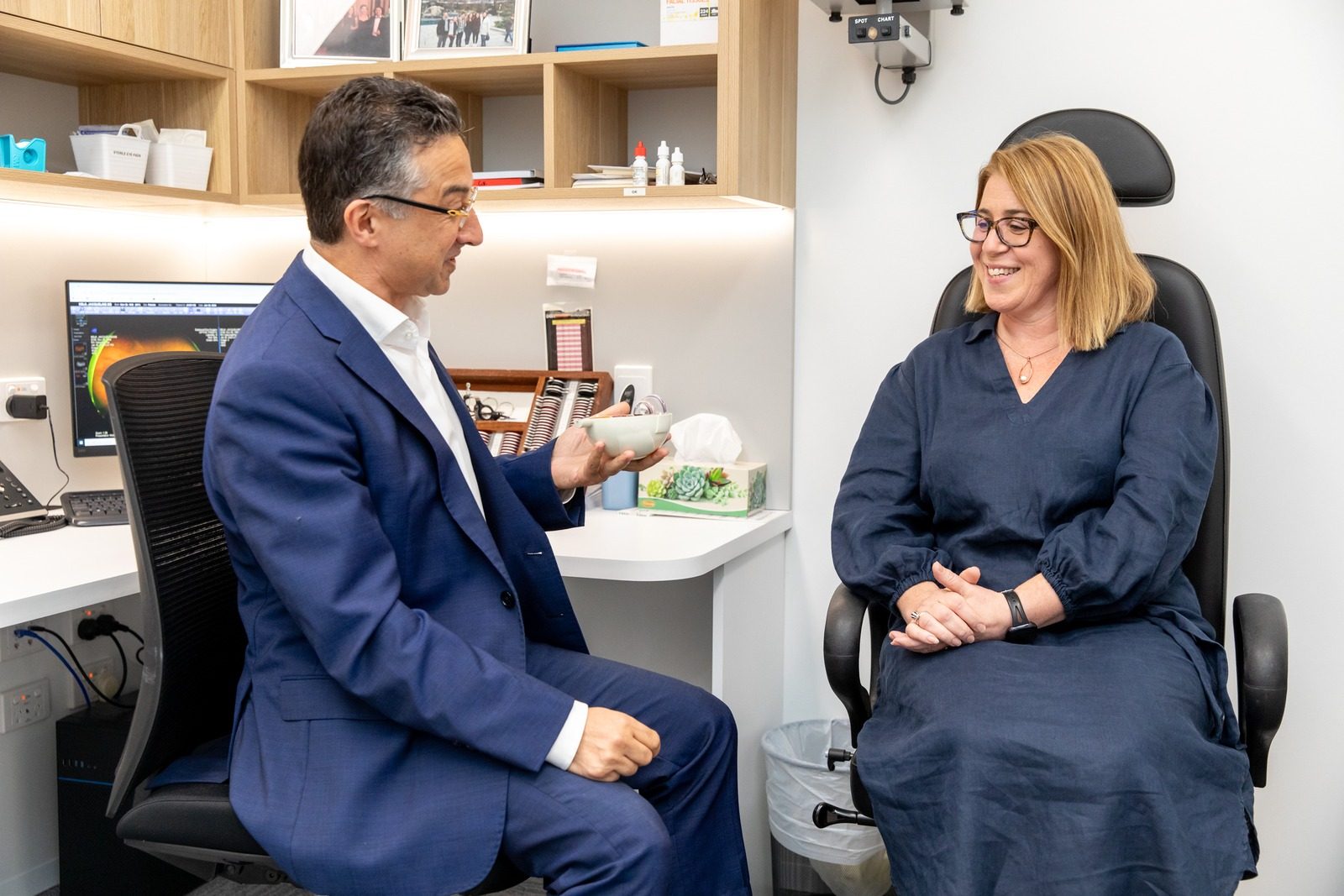 Eastwood Eye Surgery ophthalmologist discussing a retinal scan with a patient during a consultation